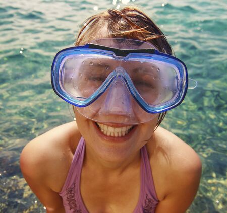 Funny girl in diving goggles at the seaの写真素材