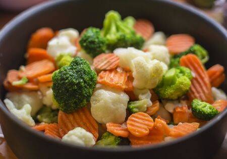 Pot full of cutted vegetables broccoli, carrot and cauliflowersの写真素材