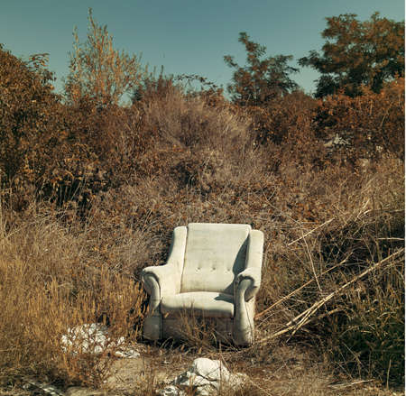 Abandoned armchair as garbage disposed in natureの写真素材