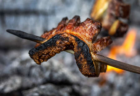 Bacon is skewer roasted at fireの写真素材