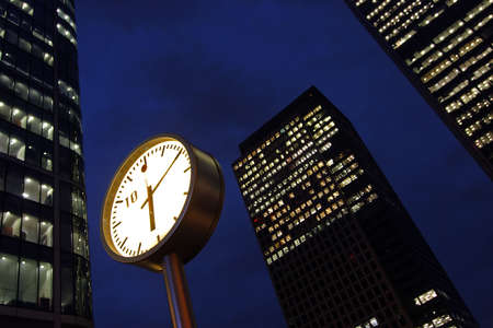 Clock and office buildings in Frankfurt, Germany at night. Night timeの写真素材