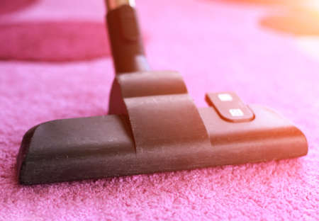Vacuum cleaner on pink towel, closeup. Cleaning serviceの写真素材