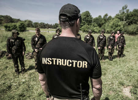 Rear view of an instructor standing in front of a group of soldiersの写真素材