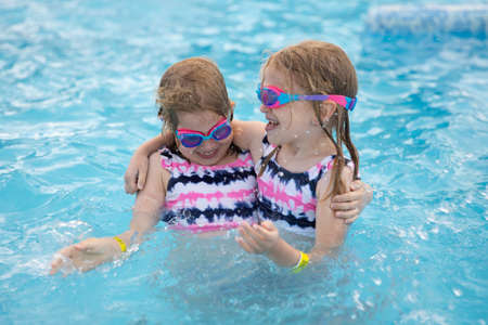 Lovely smiling children in swimming pool wearing diving gogglesの写真素材