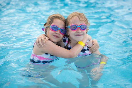 Lovely smiling children in swimming pool wearing diving gogglesの写真素材