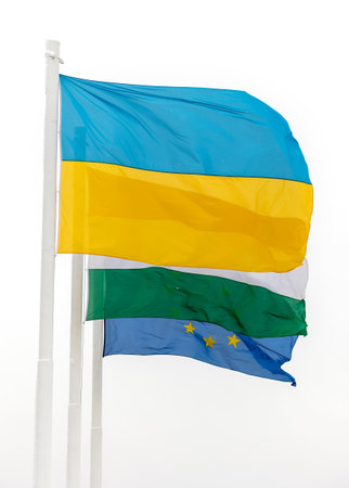 Flags of Hungary Ukraine and European Union waving on pole in winterの写真素材