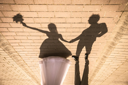 Shadow of posing wedding couple on groundの写真素材