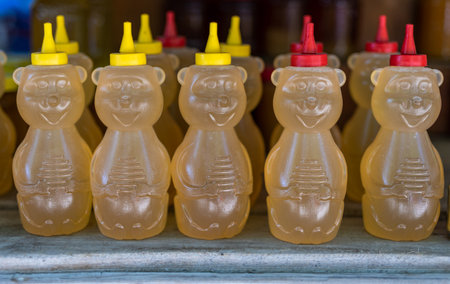 Golden sweet honey in plastic bottle in grocery market outdoorの写真素材