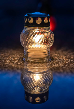 Candle in lantern on graveyard in cemetery at nightの写真素材