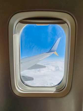 Airplane flying above clouds view from inside through windowの写真素材