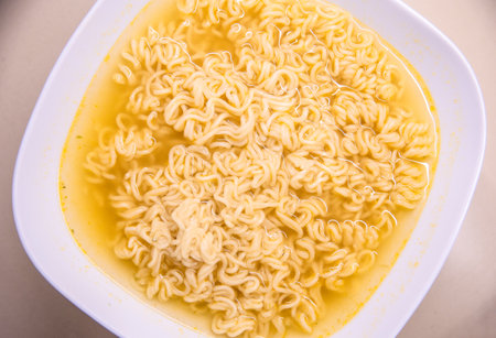 Instant asian soup with boiled noodles and chopsticksの写真素材