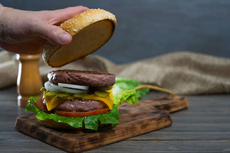 Complete burger with lettuce, cucumber, tomato, onion and cheddar cheeseの写真素材
