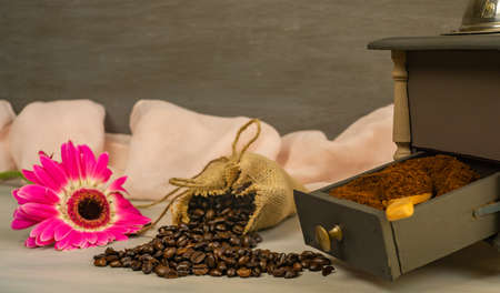 coffee beans and ground coffee with coffee grinder and flowersの写真素材