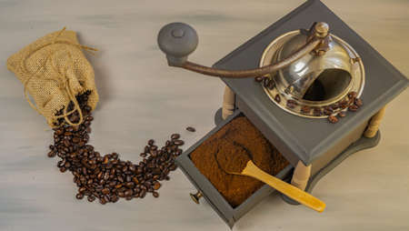 coffee beans and ground coffee with coffee grinder and flowersの写真素材