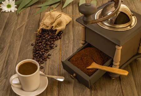 coffee beans and ground coffee with coffee grinder and flowersの写真素材
