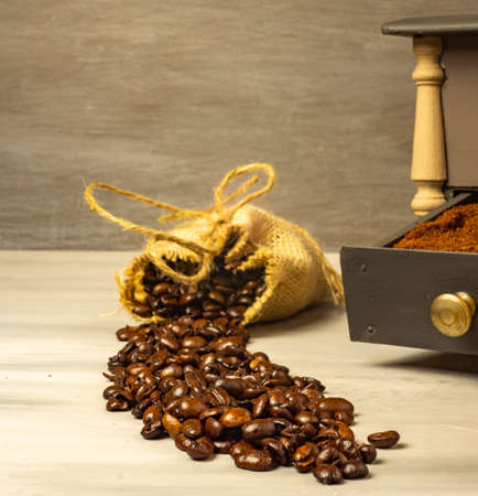 coffee beans and ground coffee with coffee grinder and flowersの写真素材