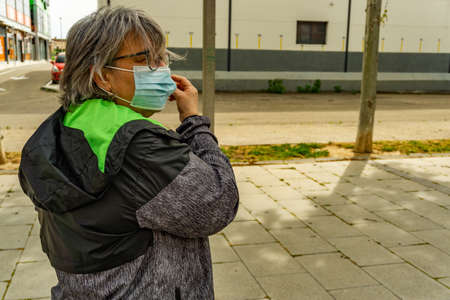 obese senior woman doing sports in the park slimming diet with face maskの写真素材