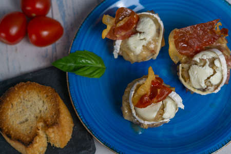 mushrooms stuffed with goat cheese, ham and cherry tomatoesの写真素材