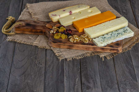 assorted cheese board with honey, nuts, blueberries and raspberries on wooden backgroundの写真素材