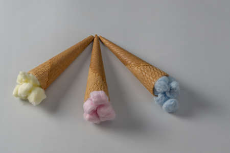 colored cotton balls in various containers on a blue backgroundの写真素材