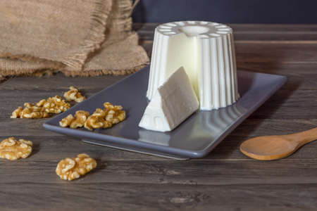 fresh cheese with honey and walnuts with different containers and backgroundsの写真素材