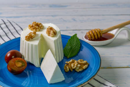 fresh cheese with honey and walnuts with different containers and backgroundsの写真素材