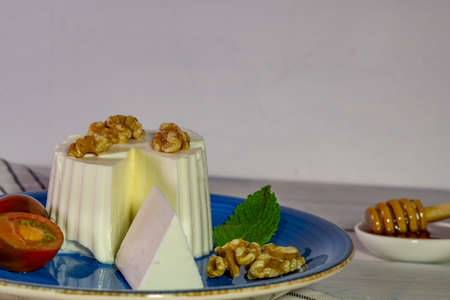 fresh cheese with honey and walnuts with different containers and backgroundsの写真素材