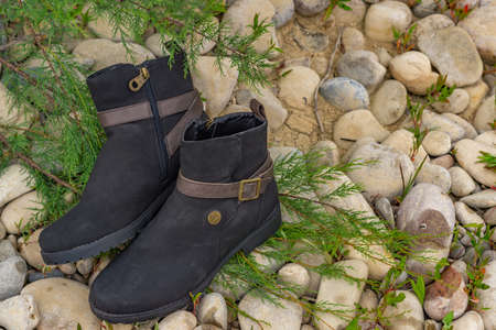 women's boots, brown and black leather on river bankの写真素材