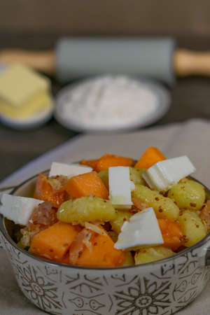 gnocchi with cheese and salmon in casserole with ingredients in the backgroundの写真素材