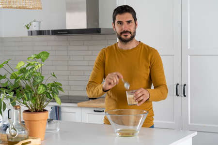 young man making homemade bread in his home kitchenの写真素材