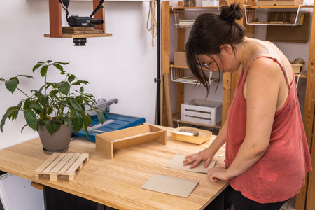 young artisan woman working in her ecological notebook workshopの写真素材