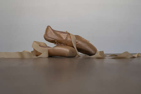 legs of girl dancing ballet with tulle skirt and pink shoes different dance steps wooden floor and...