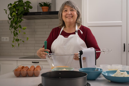 older woman with white hair making a strawberry cake in her home kitchen