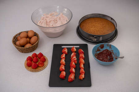 process of making a strawberry cake in a white kitchen all ingredientsの写真素材