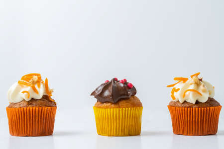 assortment of chocolate and cream and carrot cupcakes on various backgroundsの写真素材