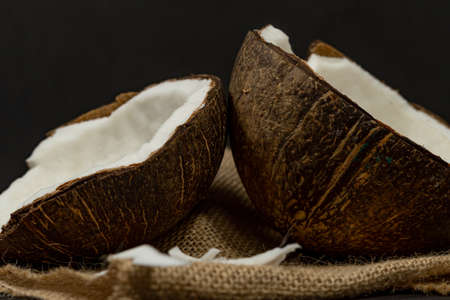 fresh coconut on black background drawing its water, raffia clothの写真素材