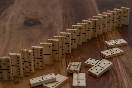 wooden dominoes in a row on a wooden tableの写真素材