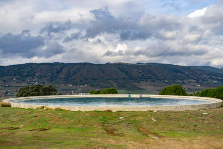water raft for forest fire service helicopter with mountains in the background and cloudy skyの写真素材