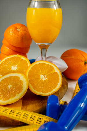 orange in the foreground with white background metric tape and copy space symbol of health and diet