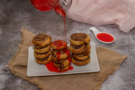 whole cinnamon and sugar roll ready to cut and bake on a white baking trayの写真素材