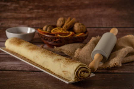 whole cinnamon and sugar roll ready to cut and bake on a white baking trayの写真素材