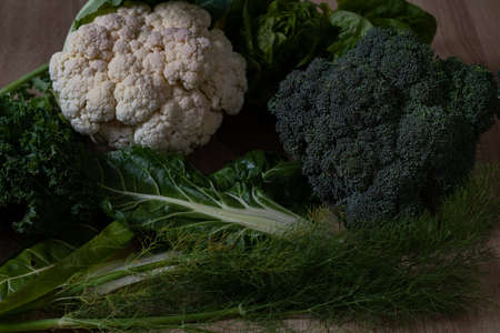 set of vegetables, cauliflower, broccoli, Swiss chard and fennel on a wooden table