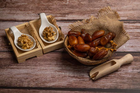 bunch of fresh dates and walnuts in a ceramic storage boxの写真素材