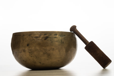 lighted incense stick on its stand with candles and flower petals on a white background and copy-spaceの写真素材