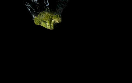 broccoli in water with splash on black background..isolated with bubblesの写真素材