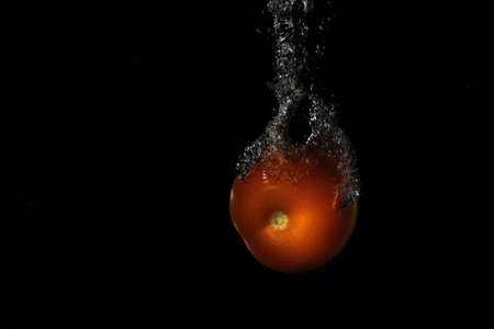 radishes splashing in the water on a black background with copy spaceの写真素材