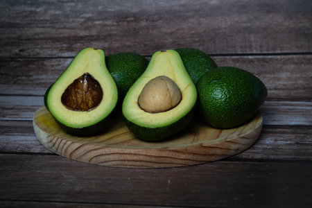 organic avocado from sustainable agriculture from andalucia, spain on a wooden board and on a raffia...