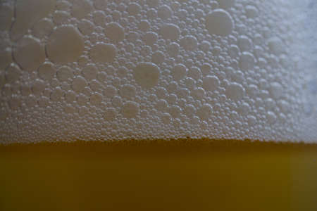 close-up of beer foam with bubbles with selective focus