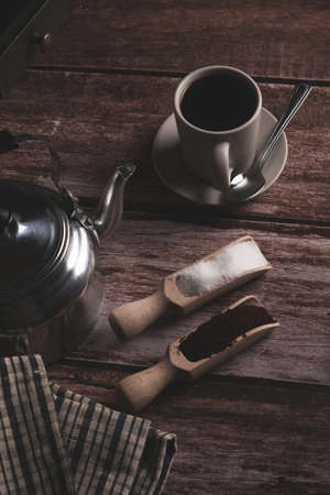 zenithal view of a coffee cup with milk jug and wooden spoons on a wooden table with text spaceの写真素材
