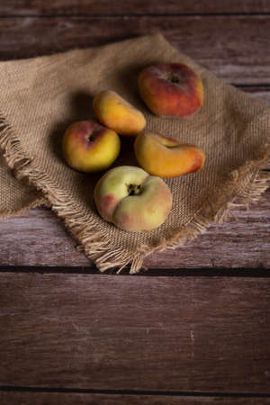 group of organic apricots on a raffia cloth on a wooden tableの写真素材